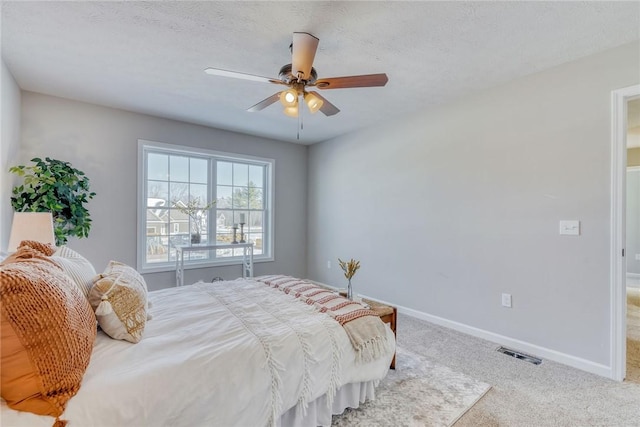 bedroom featuring visible vents, a ceiling fan, carpet flooring, a textured ceiling, and baseboards