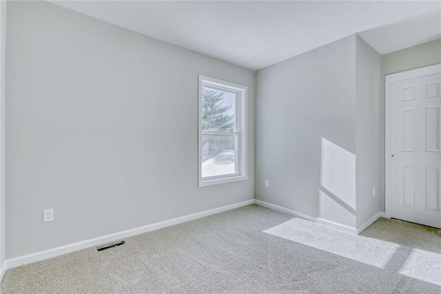 empty room featuring carpet floors, visible vents, and baseboards