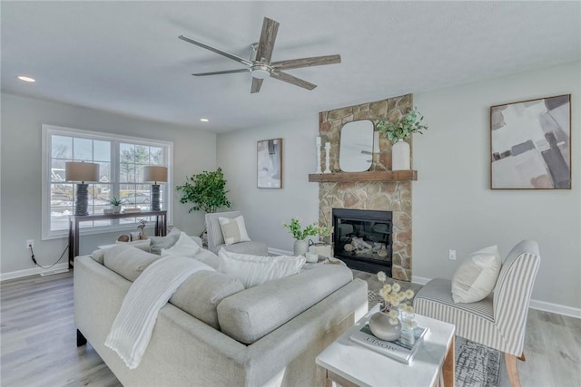 living room with recessed lighting, a fireplace, wood finished floors, a ceiling fan, and baseboards