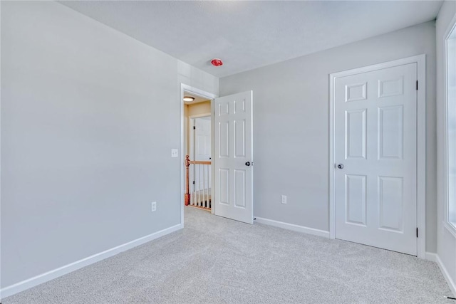 unfurnished bedroom featuring carpet floors and baseboards