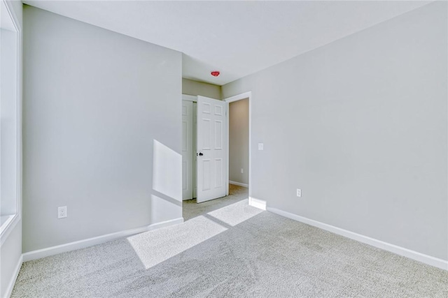 unfurnished bedroom with light colored carpet and baseboards