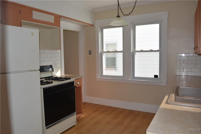 kitchen with a wealth of natural light, gas stove, freestanding refrigerator, and light countertops