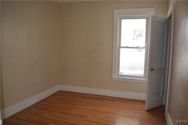 empty room with baseboards and wood finished floors