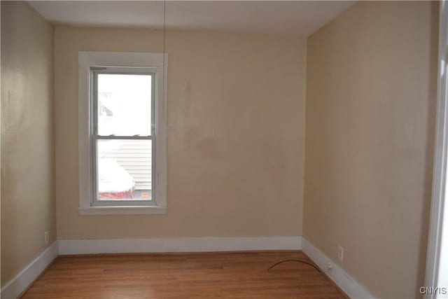 empty room with light wood-style flooring and baseboards