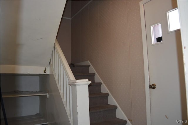 staircase with wallpapered walls