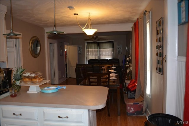 kitchen with light countertops, wood finished floors, white cabinetry, and decorative light fixtures