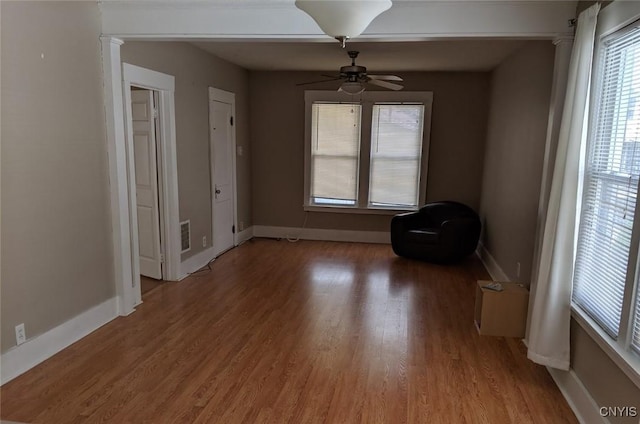 interior space with a ceiling fan, light wood-style flooring, and baseboards