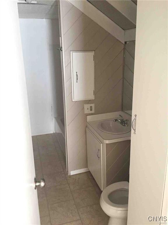 bathroom with toilet, tile patterned flooring, and vanity