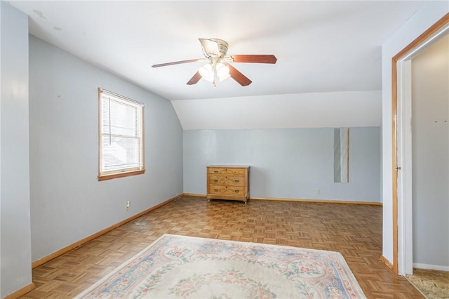 additional living space featuring vaulted ceiling, a ceiling fan, and baseboards