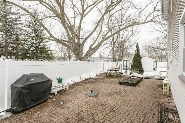 view of patio featuring an outbuilding, a shed, grilling area, and a fenced backyard