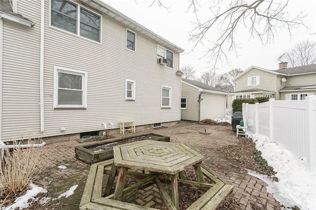 rear view of property with cooling unit, fence, and a garden