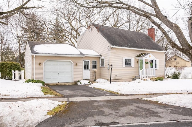 view of front of property featuring a shingled roof, a chimney, aphalt driveway, an attached garage, and fence