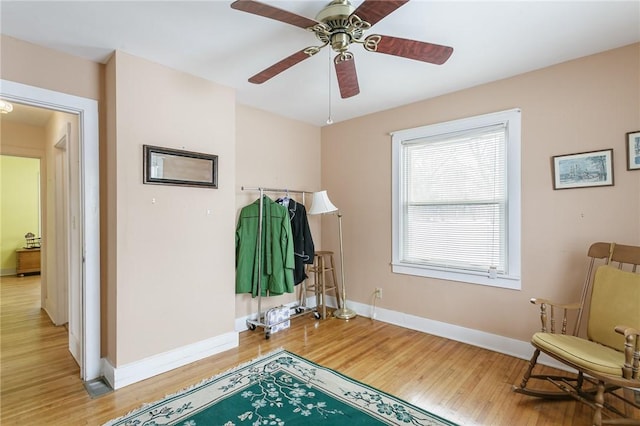 interior space featuring light wood-type flooring, baseboards, and a ceiling fan