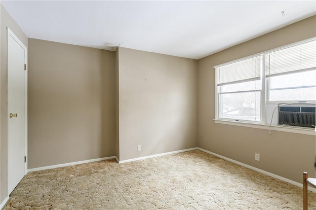 carpeted spare room featuring cooling unit and baseboards