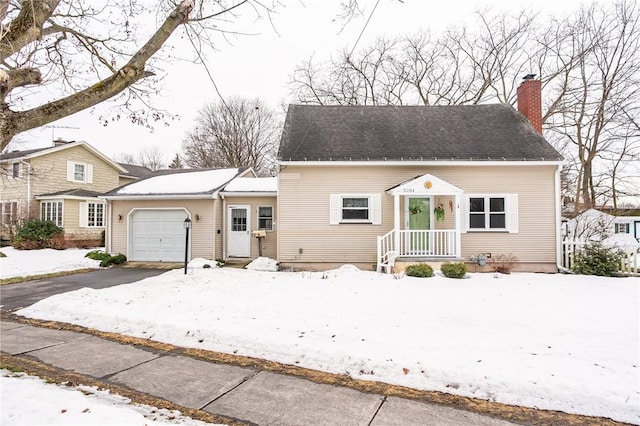 view of front facade featuring driveway, a shingled roof, a chimney, and an attached garage