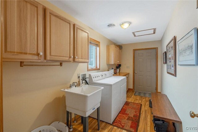 laundry area featuring cabinet space, visible vents, light wood finished floors, and separate washer and dryer