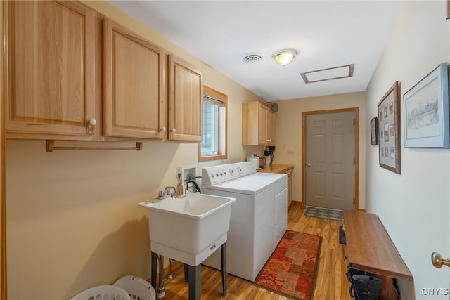 laundry room with washer and dryer, visible vents, cabinet space, and light wood-type flooring