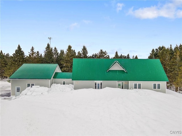 snow covered back of property with metal roof