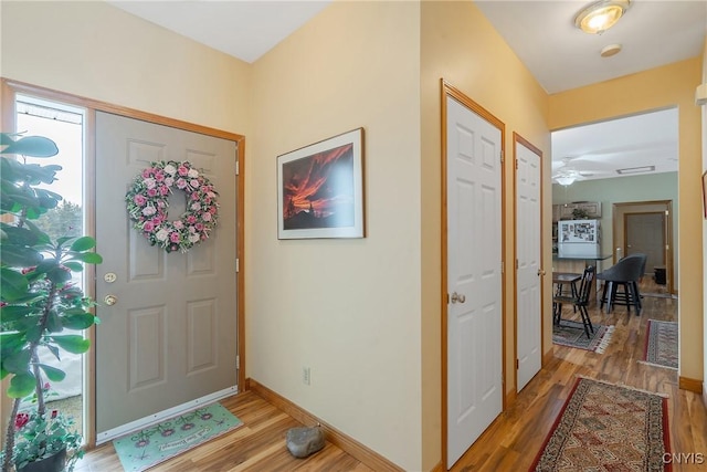 foyer entrance with light wood-type flooring and baseboards