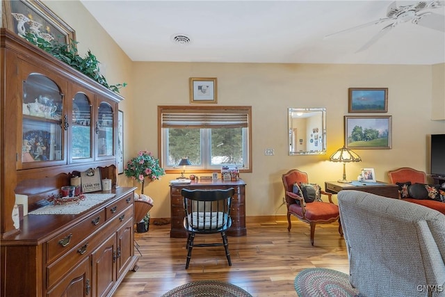 sitting room featuring visible vents, light wood-style flooring, baseboards, and ceiling fan