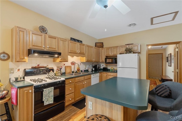 kitchen with tasteful backsplash, visible vents, under cabinet range hood, a breakfast bar area, and white appliances