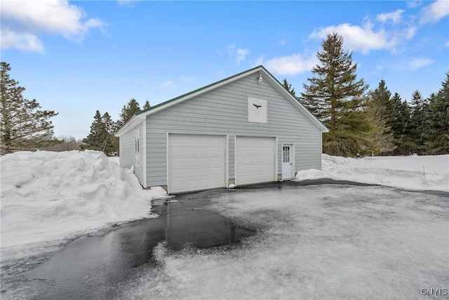 snow covered garage with a garage