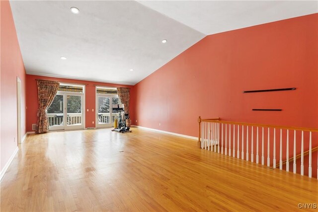 interior space featuring lofted ceiling, baseboards, wood finished floors, and recessed lighting