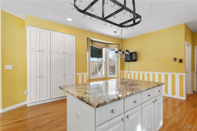 kitchen featuring baseboards, light wood-style flooring, and white cabinets