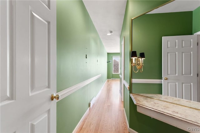 hallway featuring wood finished floors and baseboards