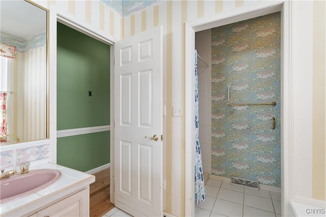 bathroom with baseboards, visible vents, vanity, and wallpapered walls