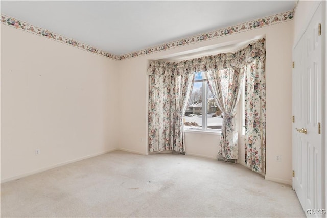 carpeted empty room featuring baseboards