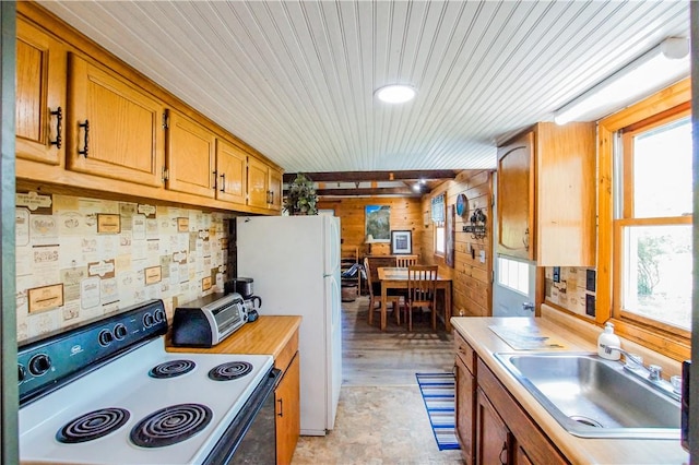 kitchen featuring light countertops, white appliances, a sink, and a healthy amount of sunlight