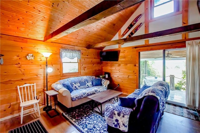 living room with vaulted ceiling with beams, wood finished floors, wood ceiling, and wooden walls