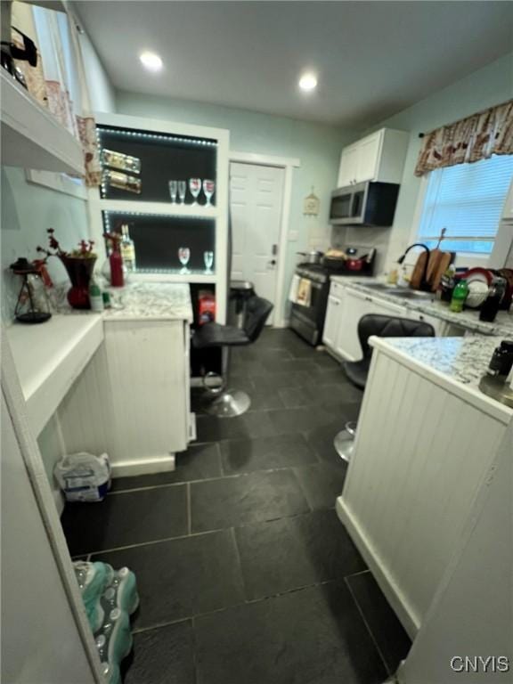 kitchen with white cabinetry, appliances with stainless steel finishes, light countertops, and recessed lighting