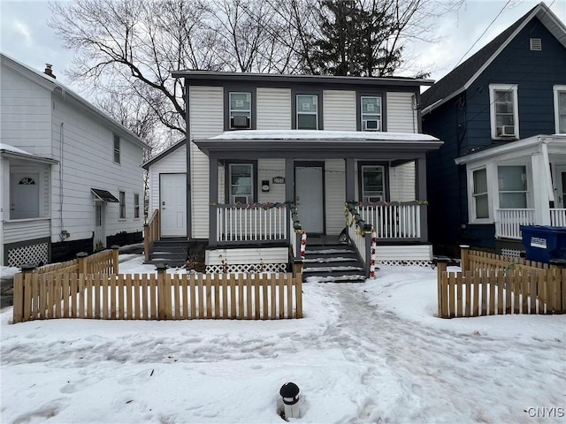 view of front of property with entry steps, covered porch, and a fenced front yard