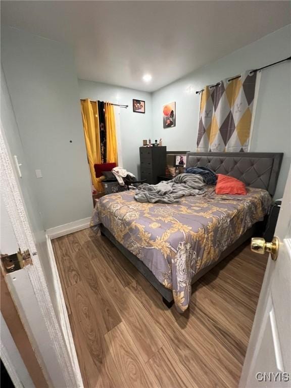 bedroom with wood finished floors and baseboards