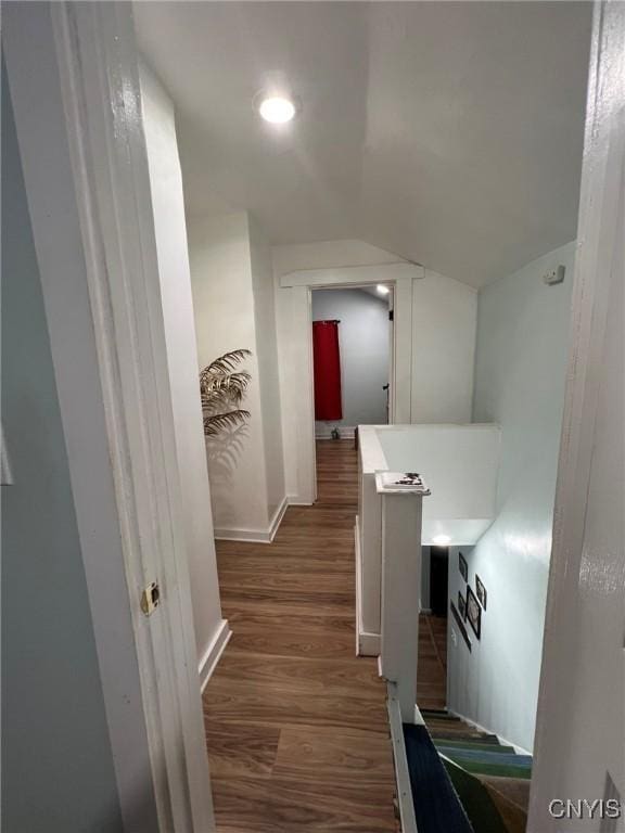 hallway with lofted ceiling, dark wood finished floors, baseboards, and recessed lighting