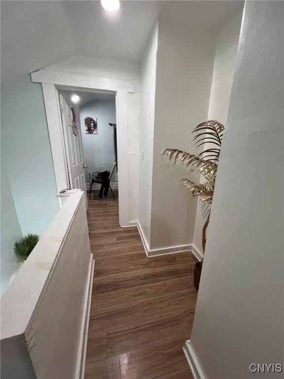 hallway featuring dark wood-style floors and baseboards