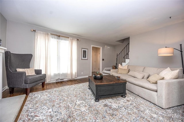 living room with stairway, baseboards, and wood finished floors