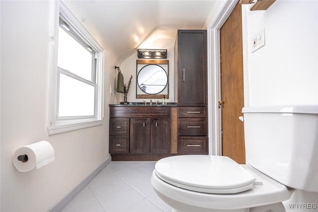 bathroom featuring baseboards, toilet, tile patterned floors, vaulted ceiling, and vanity