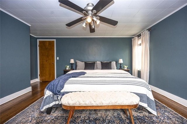 bedroom with ornamental molding, wood finished floors, a ceiling fan, and baseboards