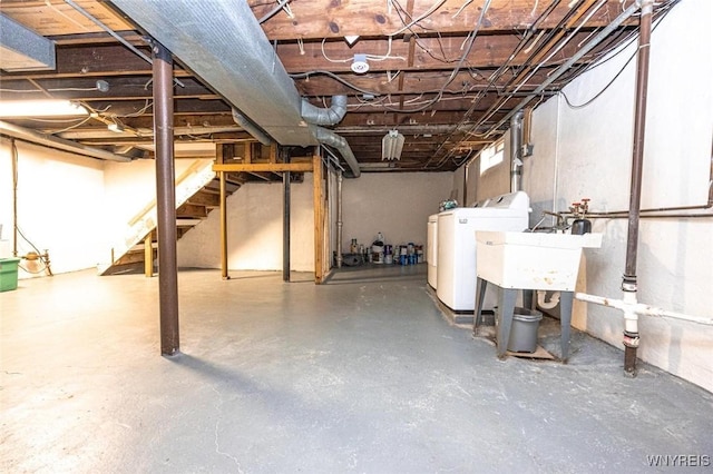 unfinished basement with separate washer and dryer and a sink