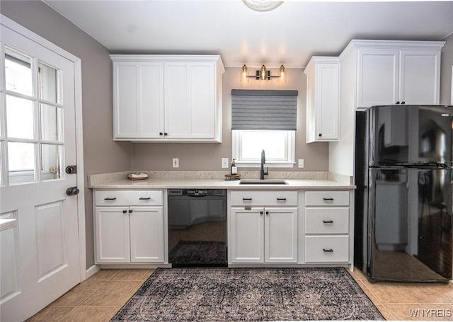 kitchen with black appliances, white cabinets, a sink, and light tile patterned flooring