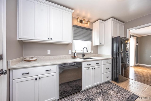 kitchen with baseboards, tile patterned floors, black appliances, white cabinetry, and a sink