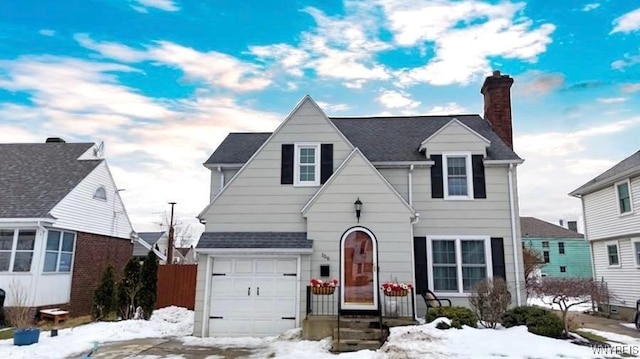 view of front facade featuring a garage, a chimney, and fence