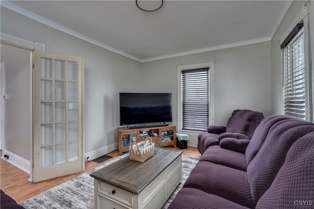 living area featuring ornamental molding, baseboards, and light wood finished floors