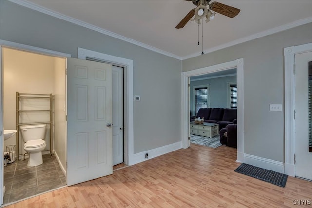 interior space featuring baseboards, light wood-style floors, and crown molding