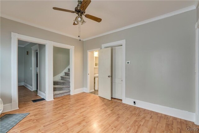 unfurnished room with light wood finished floors, baseboards, visible vents, and ornamental molding