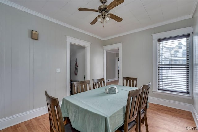 dining space with crown molding, light wood-type flooring, ceiling fan, and baseboards