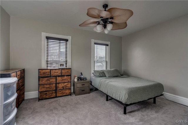 carpeted bedroom with ceiling fan and baseboards